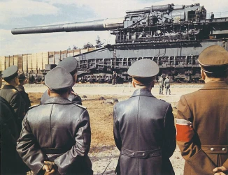 Hitler’s monster Dora 800 mm Railway Gun. Here the Fuhrer inspects his new weapon, which was first used on Sevastopol, but with relatively little strategic effect. (Speer stands to the right of Hitler, wearing a red armband. Via Flickr. Click to expand.)